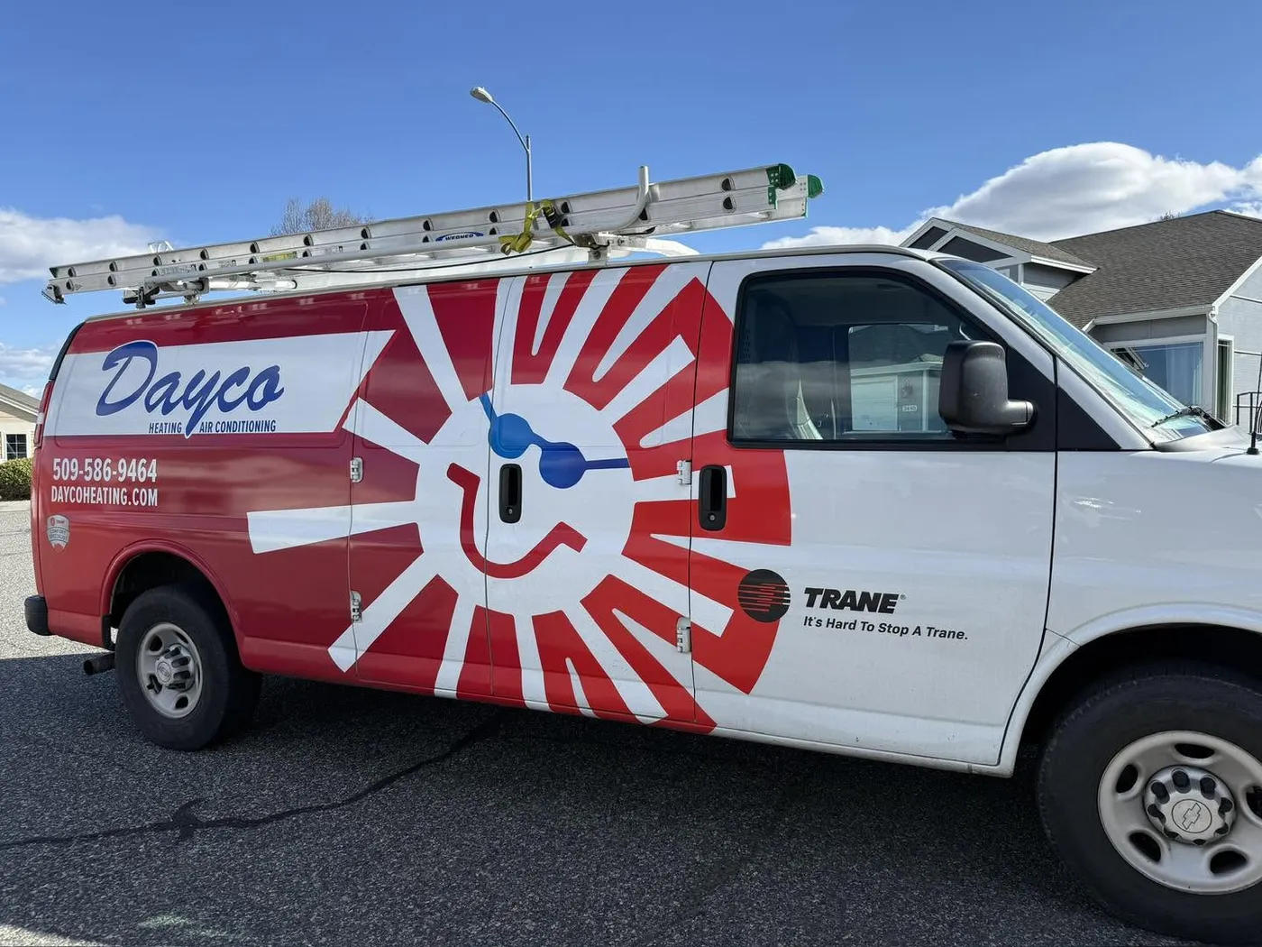 A Dayco service van wrapped with the red sun logo and a Trane badge